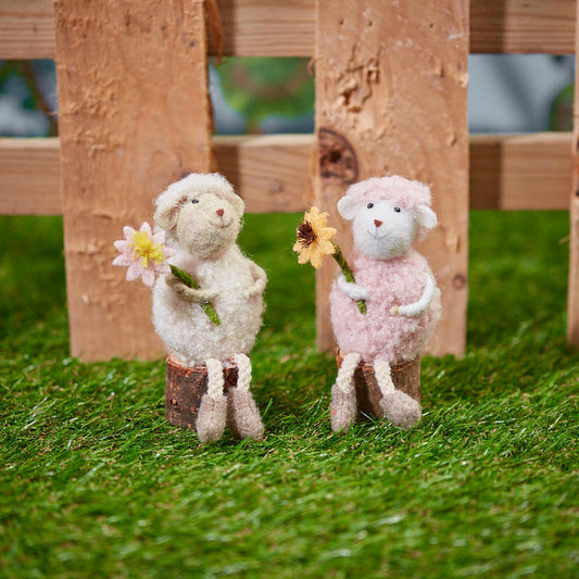 Sitting sheep with flower on wood block